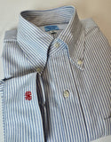 Folded blue and white striped shirt with a red logo on a beige background